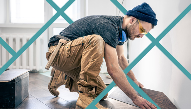 Flooring contractor installing laminate wood flooring inside a home